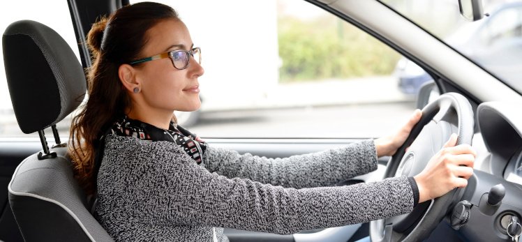 Chica con gafas conduciendo tranquilamente